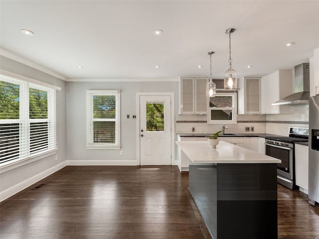 701 Bouldin Ave, Austin, TX 78704 - kitchen with wall chimney exhaust hood, appliances with stainless steel finishes, tasteful backsplash, ornamental molding, and white cabinetry