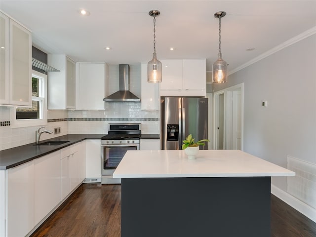 701 Bouldin Ave, Austin, TX 78704 - kitchen with appliances with stainless steel finishes, wall chimney range hood, backsplash, white cabinets, and ornamental molding