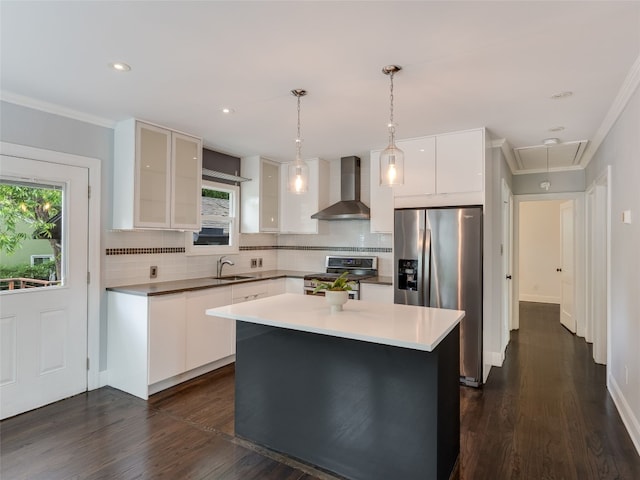 701 Bouldin Ave, Austin, TX 78704 - kitchen featuring wall chimney range hood, stainless steel appliances, decorative backsplash, white cabinetry, and crown molding