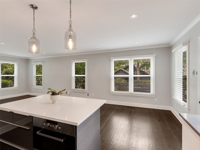 701 Bouldin Ave, Austin, TX 78704 - kitchen with dark wood-style floors, light countertops, hanging light fixtures, open floor plan, and ornamental molding