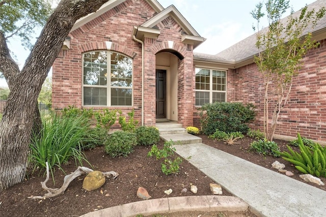 entrance to property featuring brick siding