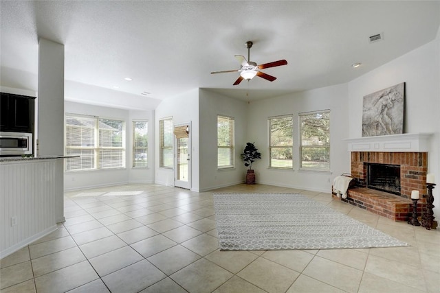 unfurnished living room with light tile patterned flooring, a brick fireplace, plenty of natural light, ceiling fan, and recessed lighting