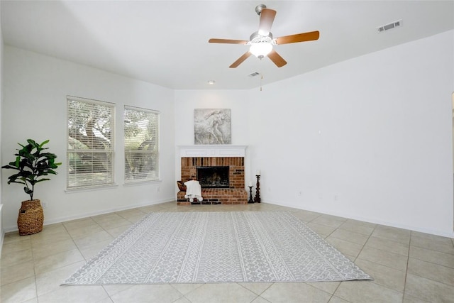 living room featuring a brick fireplace, tile patterned floors, and ceiling fan