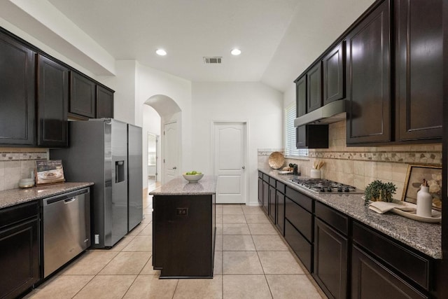 4924 Pyrenees Pass, Bee Cave, TX 78738 - kitchen featuring appliances with stainless steel finishes, arched walkways, a center island, under cabinet range hood, and decorative backsplash