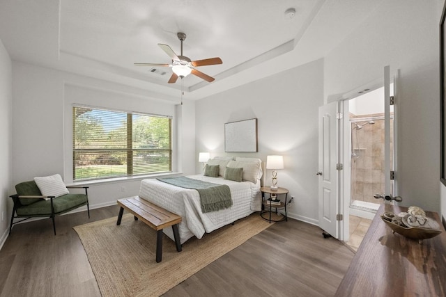 4924 Pyrenees Pass, Bee Cave, TX 78738 - bedroom with a raised ceiling, wood finished floors, ceiling fan, and ensuite bathroom