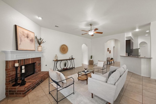 4924 Pyrenees Pass, Bee Cave, TX 78738 - living area featuring arched walkways, light tile patterned floors, a ceiling fan, a fireplace, and recessed lighting