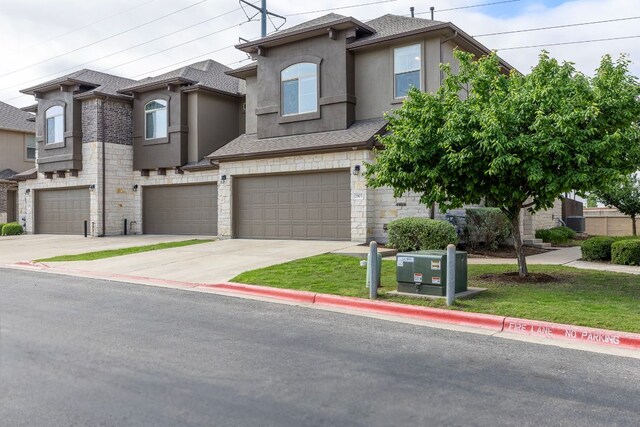 2880 Donnell Dr Unit 3903, Round Rock, TX 78664 - view of front of property with stucco siding, stone siding, an attached garage, concrete driveway, and roof with shingles
