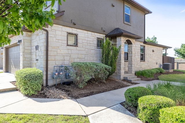 2880 Donnell Dr Unit 3903, Round Rock, TX 78664 - view of front of home with stone siding, central AC, stucco siding, fence, and a garage