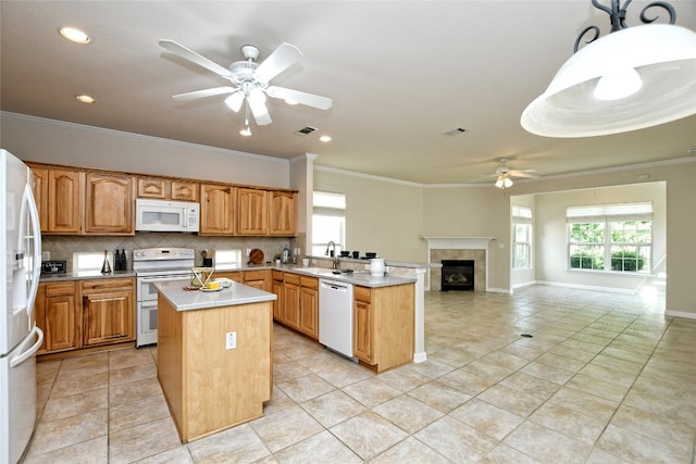 212 Yukon Ter, Georgetown, TX 78633 - kitchen with white appliances, a ceiling fan, a peninsula, ornamental molding, and a kitchen island