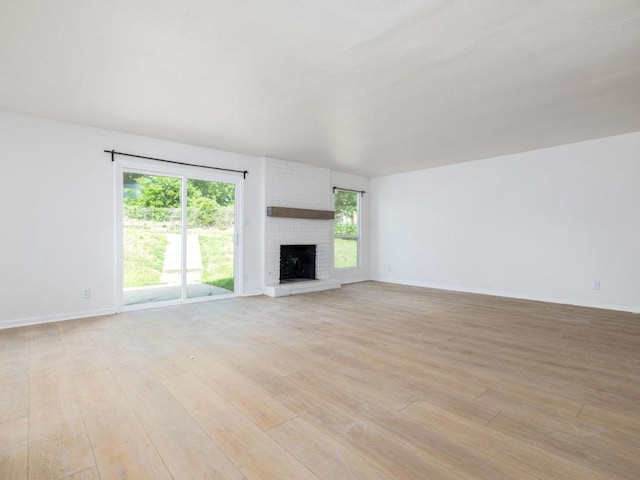 2522 Chaparral Trl, Austin, TX 78744 - unfurnished living room featuring light wood finished floors and a brick fireplace