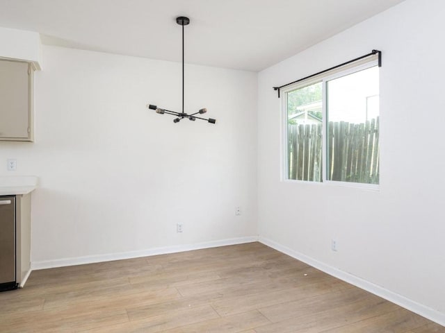 unfurnished dining area with light wood-style flooring and baseboards