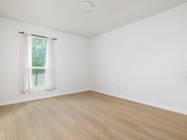 empty room featuring light wood-type flooring and baseboards