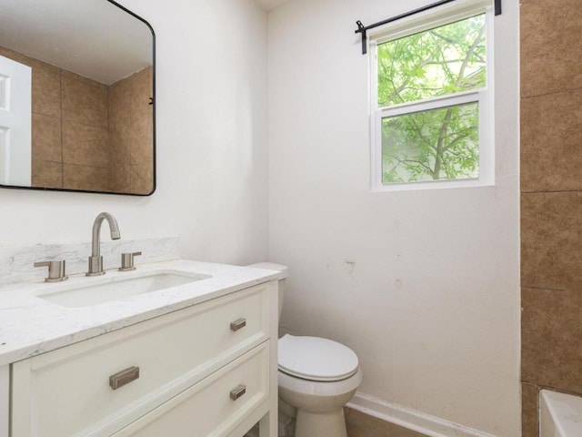 full bathroom with toilet, vanity, baseboards, and a bath