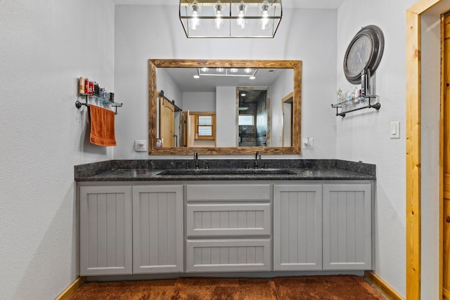 full bathroom featuring double vanity and baseboards