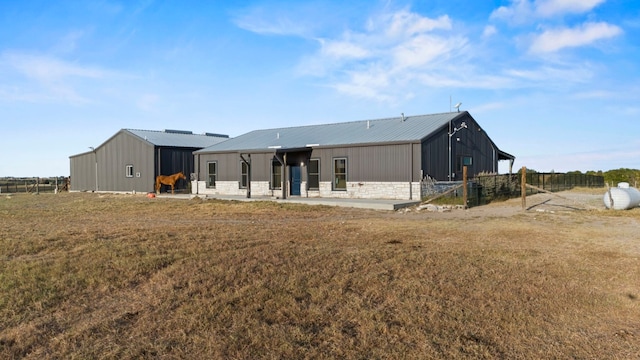 back of house featuring a patio, metal roof, and board and batten siding