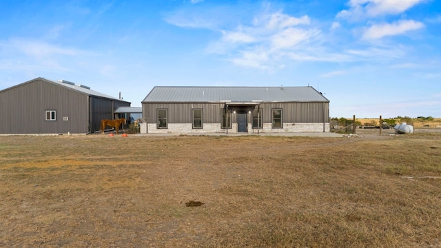 back of property with metal roof and a yard
