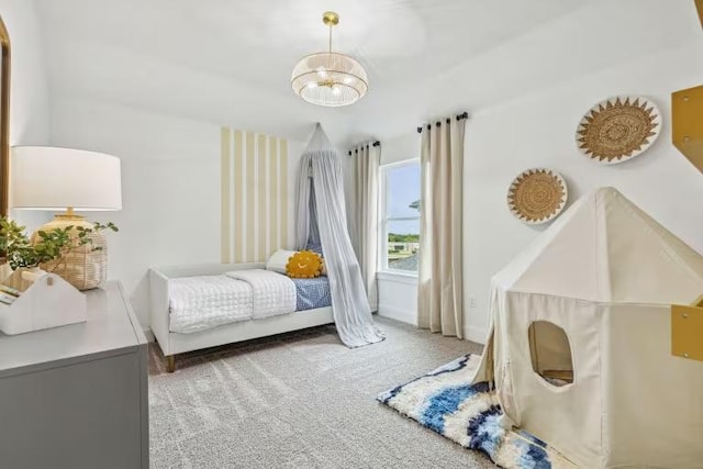 carpeted bedroom with a chandelier and baseboards