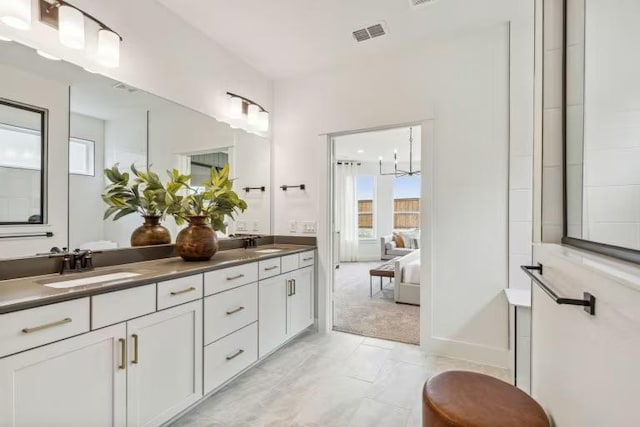 bathroom featuring double vanity, plenty of natural light, and marble look tile flooring