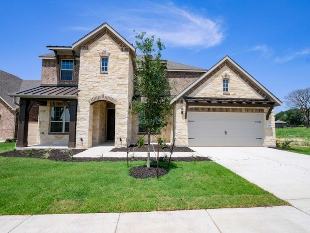 1709 Cayuga St, Leander, TX 78641 - french country style house with stone siding, a standing seam roof, a front yard, concrete driveway, and an attached garage