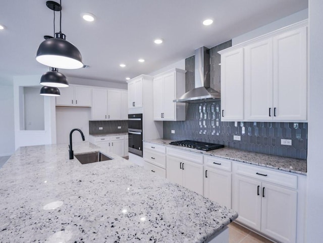1709 Cayuga St, Leander, TX 78641 - kitchen featuring wall chimney range hood, a sink, gas cooktop, multiple ovens, and white cabinetry