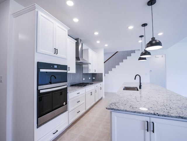 1709 Cayuga St, Leander, TX 78641 - kitchen with a sink, wall chimney range hood, double oven, gas stovetop, and white cabinetry