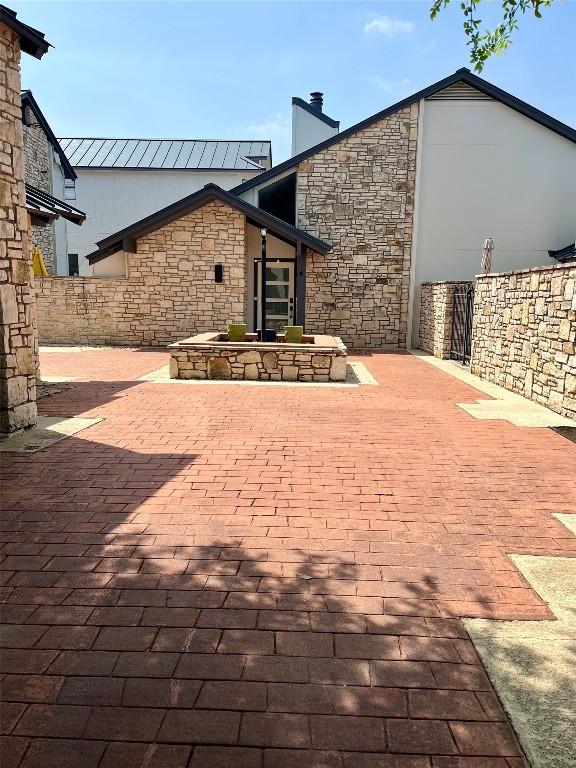 103 Island Dr Unit 8, Horseshoe Bay, TX 78657 - back of house with stone siding, a patio area, a chimney, and fence