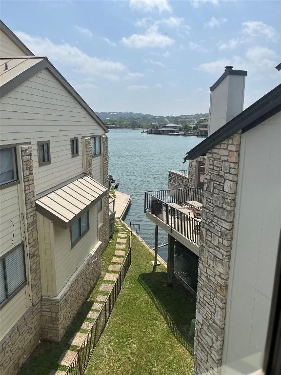 103 Island Dr Unit 8, Horseshoe Bay, TX 78657 - view of side of property featuring a water view, stone siding, and a yard