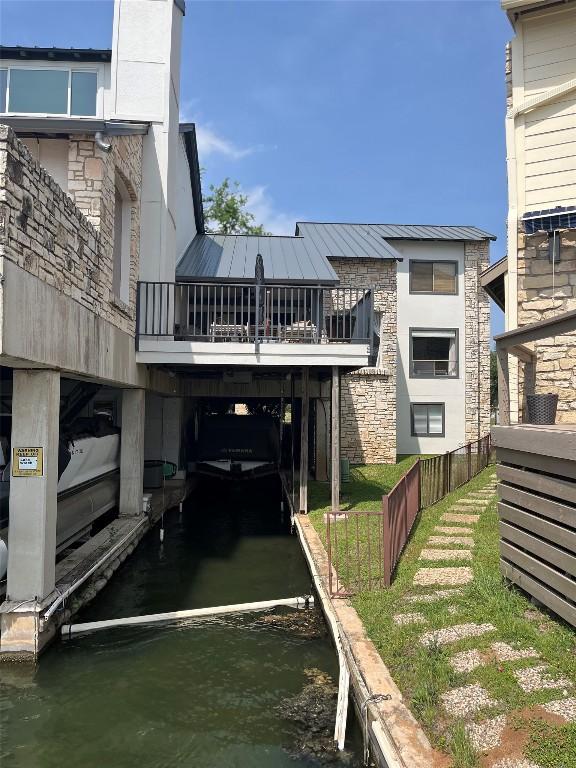 103 Island Dr Unit 8, Horseshoe Bay, TX 78657 - back of property with stone siding, a water view, metal roof, and fence