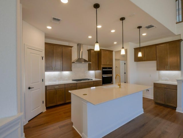 2916 Carrizo Ter, Leander, TX 78641 - kitchen with wall chimney exhaust hood, double oven, a sink, dark wood finished floors, and decorative backsplash