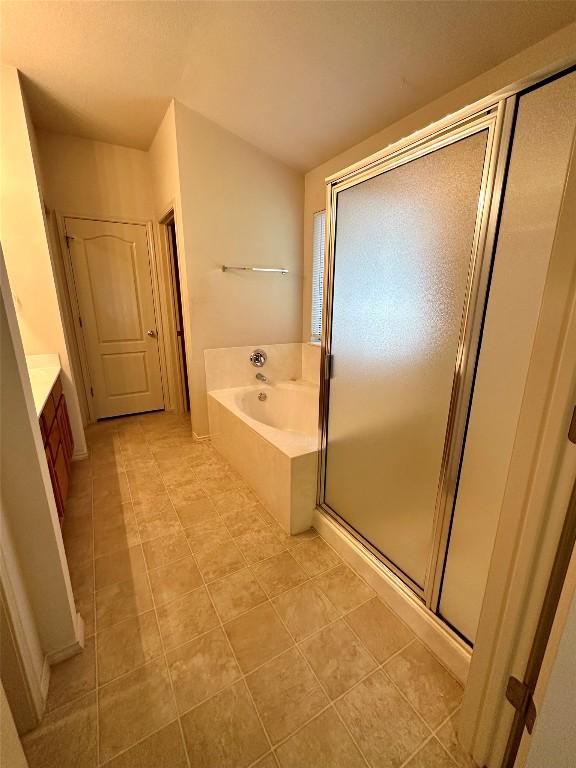 4526 Tello Path, Austin, TX 78749 - bathroom featuring a garden tub, a stall shower, tile patterned flooring, and vanity