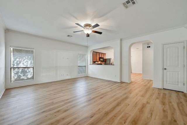 2408 Amur Dr, Austin, TX 78745 - unfurnished living room featuring ceiling fan, ornamental molding, light wood-type flooring, baseboards, and arched walkways