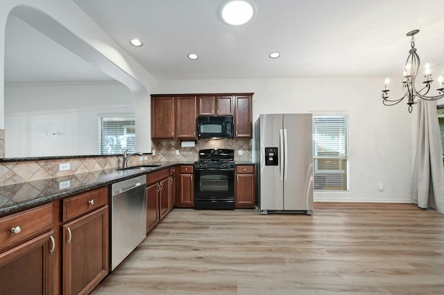 2408 Amur Dr, Austin, TX 78745 - kitchen featuring black appliances, a sink, plenty of natural light, light wood finished floors, and recessed lighting