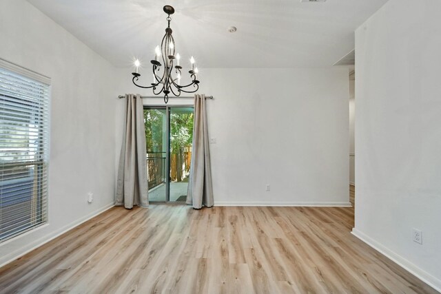 2408 Amur Dr, Austin, TX 78745 - unfurnished dining area with wood finished floors, a chandelier, and baseboards