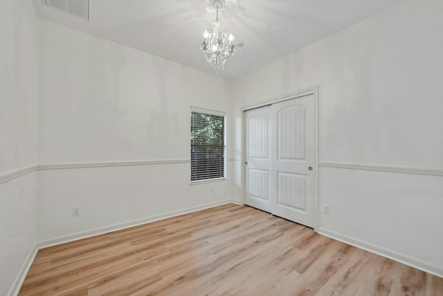 2408 Amur Dr, Austin, TX 78745 - unfurnished bedroom featuring a chandelier, wood finished floors, baseboards, and a closet