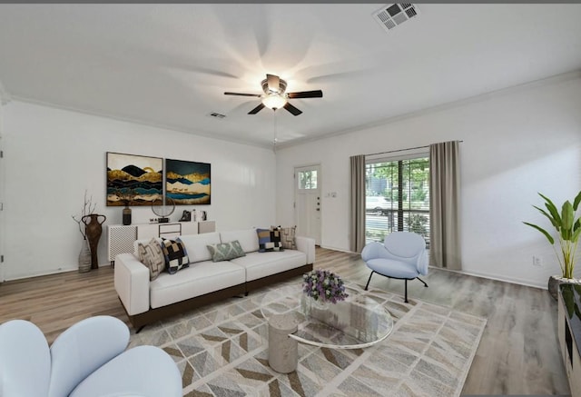 2408 Amur Dr, Austin, TX 78745 - living room featuring light wood-style flooring, a ceiling fan, ornamental molding, and baseboards