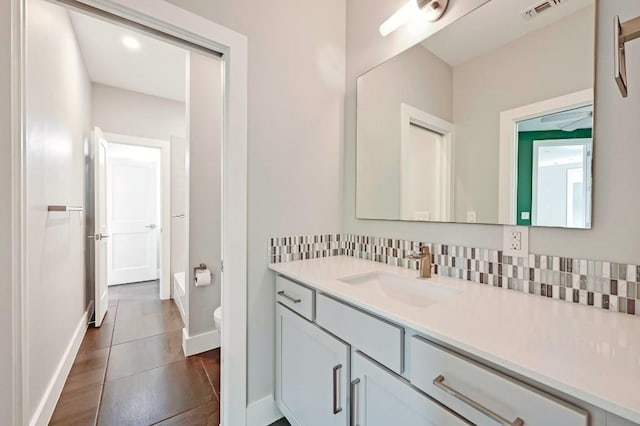 2305 E 16th St Unit A, Austin, TX 78702 - bathroom featuring vanity, backsplash, toilet, and baseboards