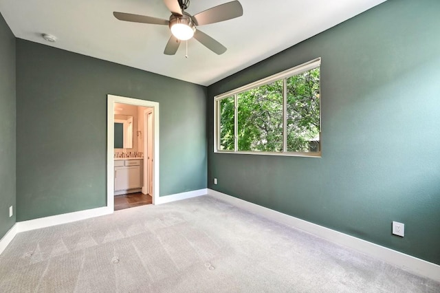 2305 E 16th St Unit A, Austin, TX 78702 - unfurnished bedroom featuring carpet flooring, baseboards, connected bathroom, and a ceiling fan