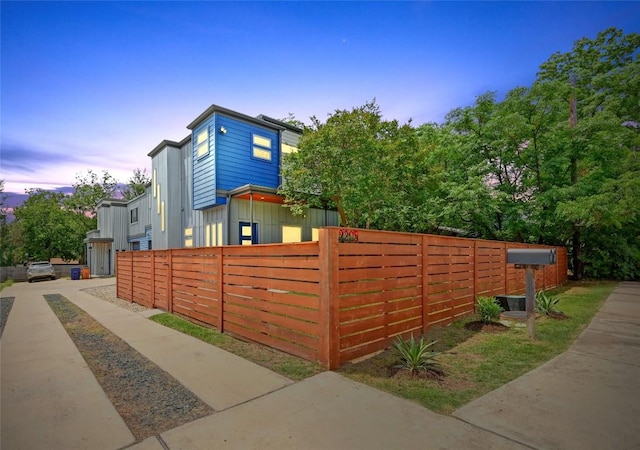 2305 E 16th St Unit A, Austin, TX 78702 - property exterior at dusk featuring board and batten siding and a fenced front yard