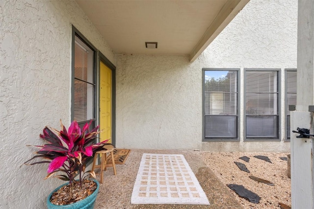 view of exterior entry featuring stucco siding