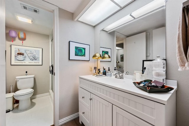 bathroom with toilet, vanity, and baseboards