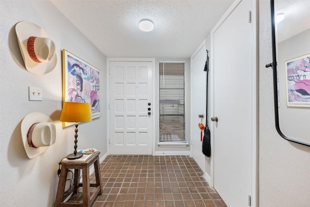 foyer with a textured ceiling and baseboards