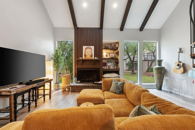 living area featuring beam ceiling, wood finished floors, a large fireplace, high vaulted ceiling, and recessed lighting