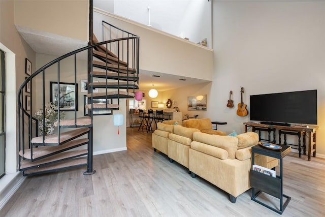 living room with wood finished floors, stairway, and baseboards