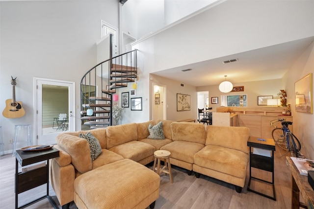 living area featuring a high ceiling, wood finished floors, and stairs