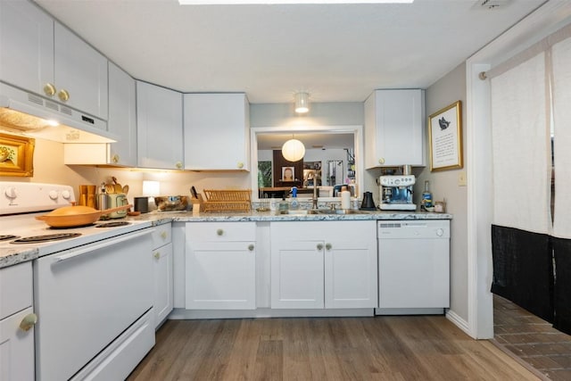 kitchen with white appliances, under cabinet range hood, a sink, wood finished floors, and white cabinetry