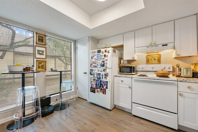 kitchen with white appliances, under cabinet range hood, light wood finished floors, light countertops, and white cabinets