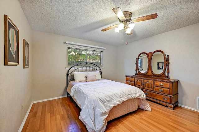 11519 Shakespearean Way, Austin, TX 78759 - bedroom featuring light wood-style flooring, a textured ceiling, baseboards, and ceiling fan