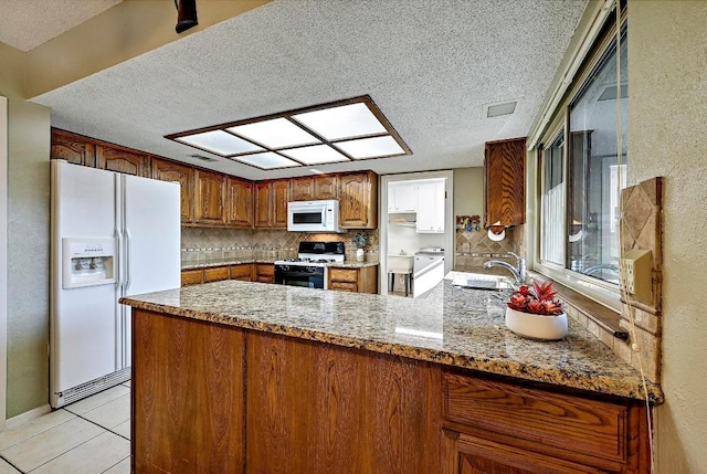 11519 Shakespearean Way, Austin, TX 78759 - kitchen featuring white appliances, a textured ceiling, a sink, a peninsula, and tasteful backsplash