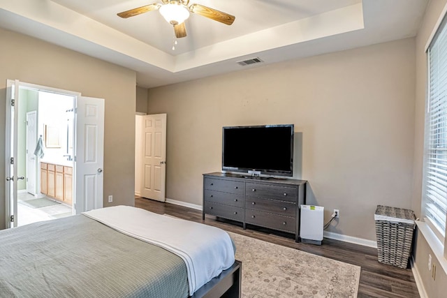 6419 Ira Ingram Dr, Austin, TX 78749 - bedroom with wood finished floors, a tray ceiling, ensuite bath, and ceiling fan