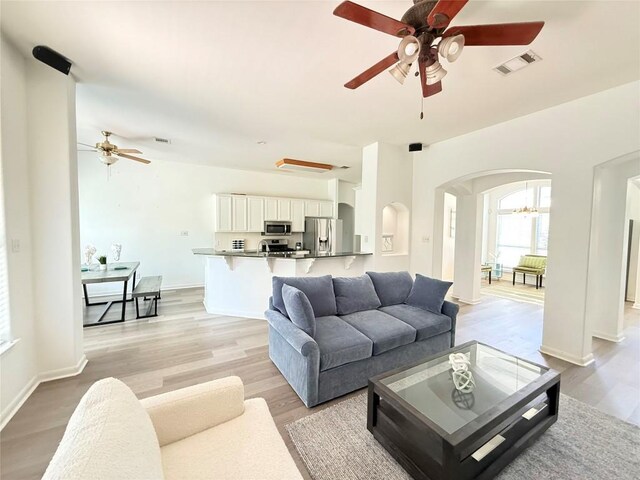 6419 Ira Ingram Dr, Austin, TX 78749 - living area with a ceiling fan, arched walkways, light wood-style flooring, and a chandelier